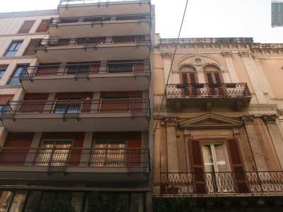 Foto 6. Infine, ad angolo con via Marchese di Montrone, ecco una palazzina grigia e bordeaux innalzarsi accanto a una casa d�epoca con lesene e decori floreali che circondano le particolari persiane arrotondate al piano superiore e l�imponente timpano al piano inferiore 